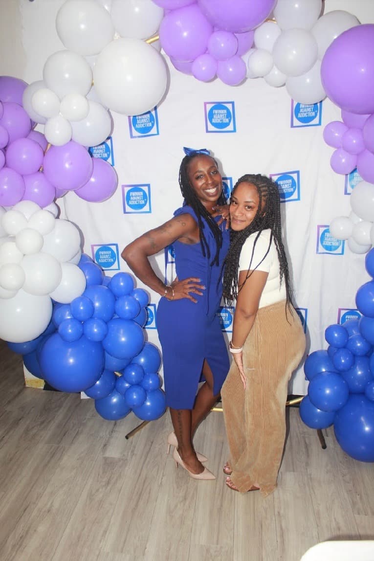 2024 Winnin Against Addiction gala attendees celebrating with branded photo backdrop in Boston