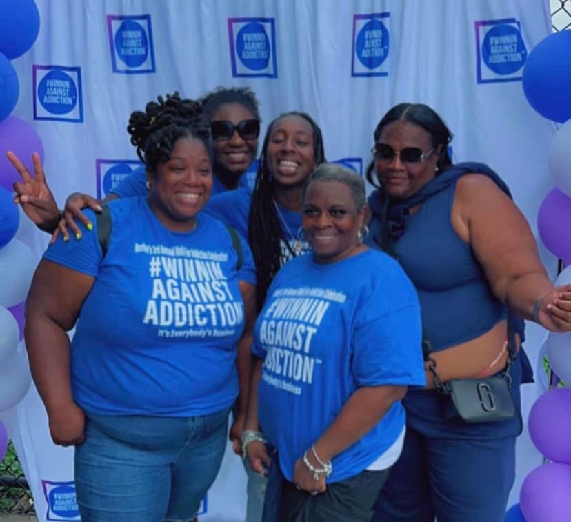 2022 volunteers in Winnin Against Addiction shirts at photo booth celebrating recovery in Boston