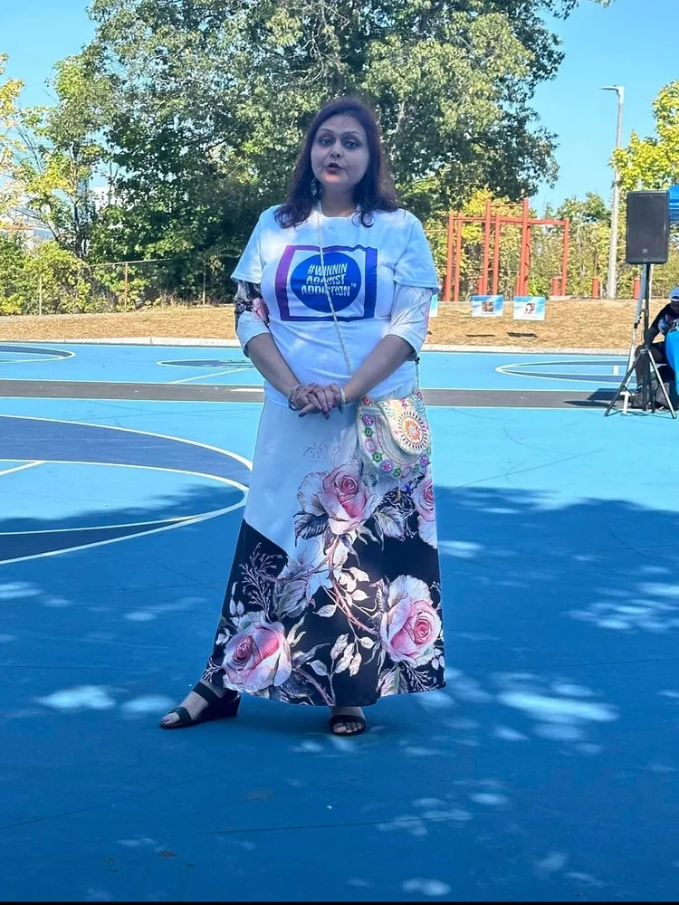 Community advocate at Winnin Against Addiction event on blue basketball court in Boston