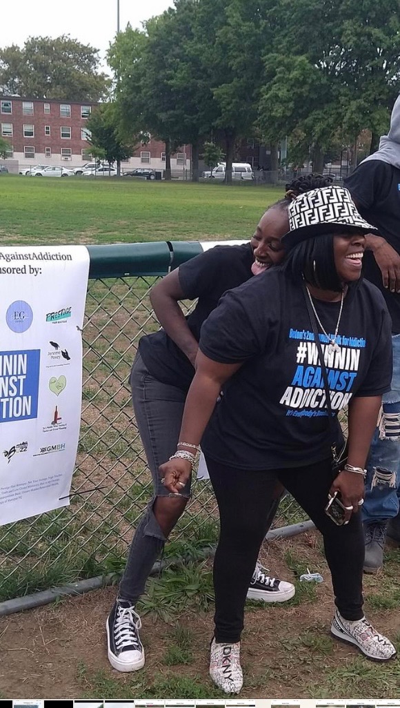 2023 community walk participants at Winnin Against Addiction Boston event with sponsor signage