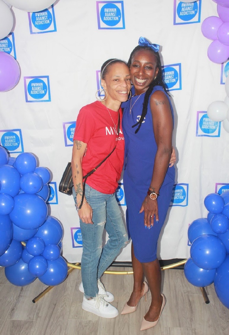 2024 Winnin Against Addiction annual gala attendees at photo booth with branded balloon backdrop in Boston