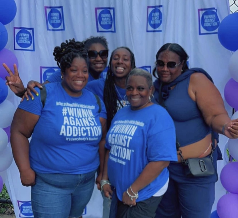 2022 volunteers in Winnin Against Addiction shirts at photo booth celebrating recovery in Boston