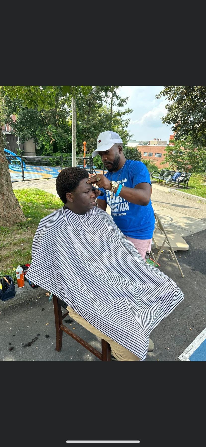 2022 barber providing free haircut services at Winnin Against Addiction community outreach in Boston